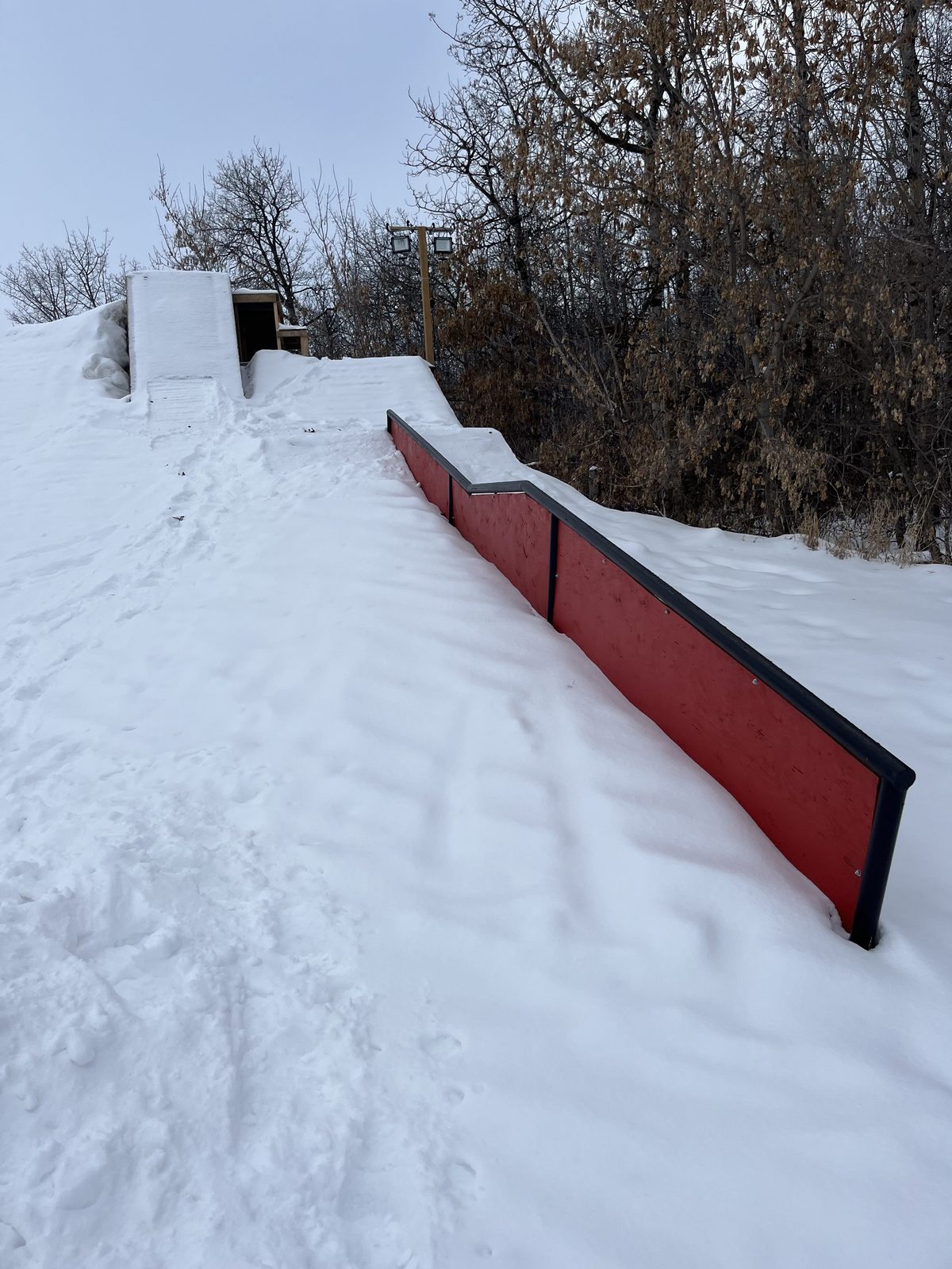Red down-flat-down rail on a snowy hill